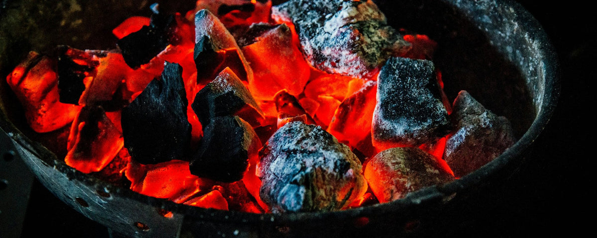 How to light a kamado: glowing lumps of charcoal in a round charcoal basket
