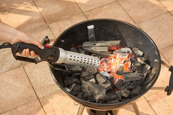 BBQ lighter bringing charcoal to a glow in a kettle barbecue